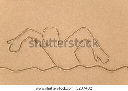 Sand drawing of a person swimming.