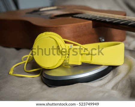 CD player,headphone and guitar on bed