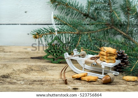 Cookies stars on a sled on wooden background with branches of Christmas tree