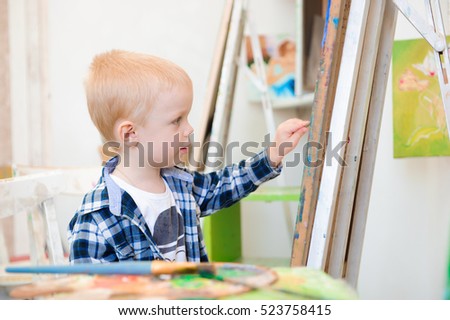 a child draws a picture paints on art lesson.
