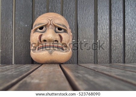 Japanese theater masks made of wooden on brown wood background,male mask