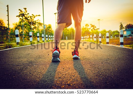 filter and tone photo ; handsome man running on road with solar power plant in morning ;Healthy lifestyle with green energy