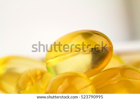 Natural food supplement, yellow gel pills Vitamin E capsules, macro image Royalty-Free Stock Photo #523790995