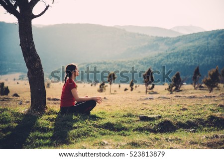 Meditating in nature on a sunny day. Finding inner peace. Practicing yoga. Well-being and healthy lifestyle concept.Enjoying peace and quiet,anti-stress therapy,mindfulness concept. Royalty-Free Stock Photo #523813879