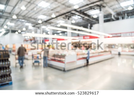 Blurred image customers shopping for fresh raw beef, pork, chicken, fish at meat department in wholesale store in US. Fully loaded shelves with variety of meat slices in boxes in a large supermarket. Royalty-Free Stock Photo #523829617