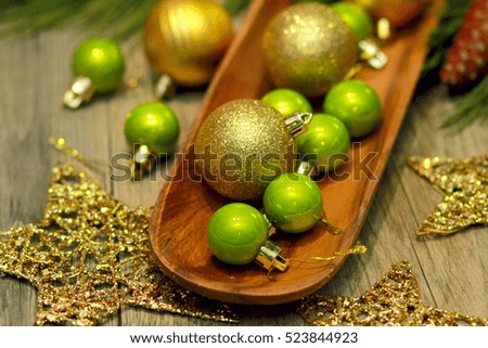 Green and Gold Christmas balls on wooden tray, gold stars