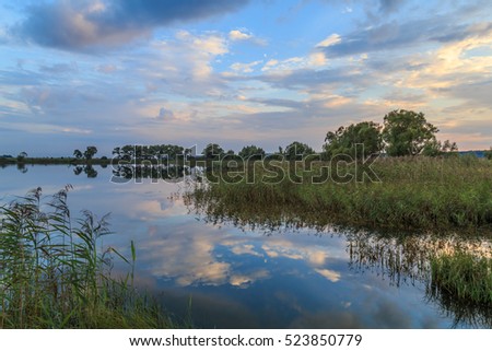 Beautiful sunset over the forest lake, evening landscape