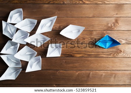Set of origami boats on wooden table Royalty-Free Stock Photo #523859521