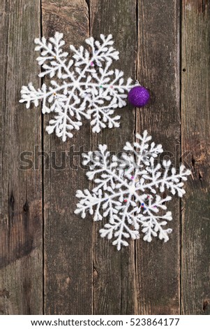 White snowflake and New Year's ball on a wall from old boards. A fluffy snowflake - Christmas decoration, on the old become green boards