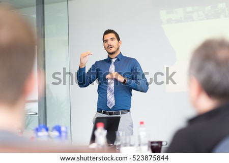 Businessman making a presentation at office. Business executive delivering a presentation to his colleagues during meeting or in-house business training, explaining new business concept and strategy. Royalty-Free Stock Photo #523875844