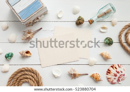 Nautical life style items: bottle with message, sea shells, chest, rope and old empty photo for the inside. Marine concept.