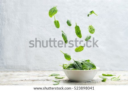 flying spinach on a wood background. tinting. selective focus Royalty-Free Stock Photo #523898041