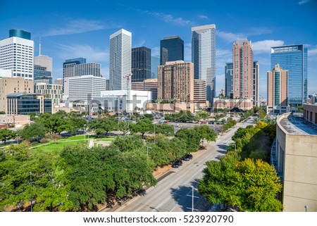 Aerial day view of Houston downtown skylines with green park trees and skyscrapers background in blue cloud sky. Houston is the most populous city in Texas and the fourth-most populous city in US.