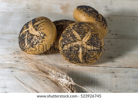 Small breads with poppy seeds and Wheat on wooden background
