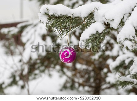 Christmas decorations on fir branches covered with snow in winter, background