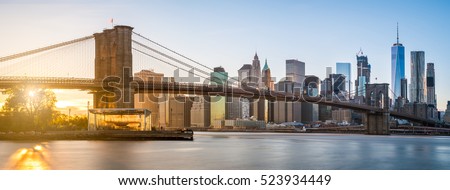 The panorama view of Brooklyn Bridge with Lower Manhattan in the background, lit by sunset Royalty-Free Stock Photo #523934449