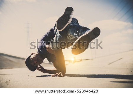 B-boy doing some stunts - Street artist breakdancing outdoors Royalty-Free Stock Photo #523946428