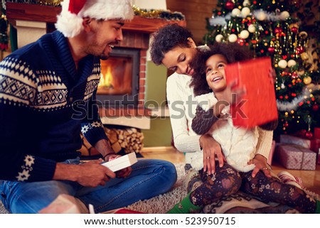 
happy surprised little girl with her parent on Christmas holiday