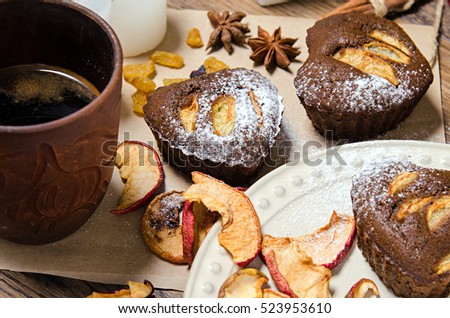 Christmas chocolate Cupcakes with apple and holiday decorations on the rustic wooden table. Holiday concept