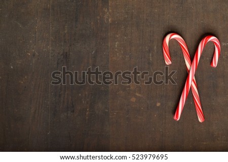 Red and white candy canes on wooden background
