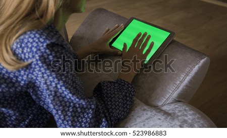 woman is relaxing on comfortable couch and using tablet at home