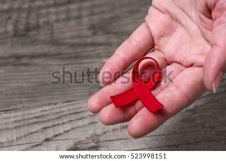 Red ribbon on palm - AIDS and HIV awareness
