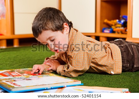 Preschool boy reading a large book