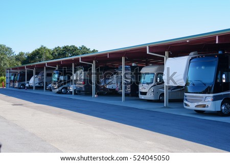 RV recreational vehicle storage parking covered garage filled with many new looking RVs and trailers. Royalty-Free Stock Photo #524045050
