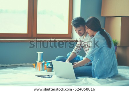 Young couple sitting on the floor of their new apartment