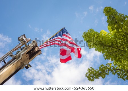 Looking up at an American Flag hanging from a fire truck
