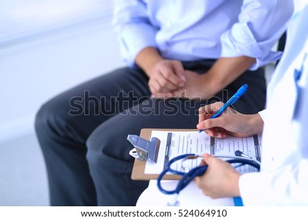 Doctor woman sitting with male patient at the desk Royalty-Free Stock Photo #524064910