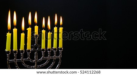 Jewish holiday hannukah low key image of jewish holiday Hanukkah with menorah traditional Candelabra and wooden dreidels spinning top . glitter overlay