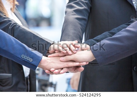 Image of businesspeople hands on top of each other as symbol of their partnership