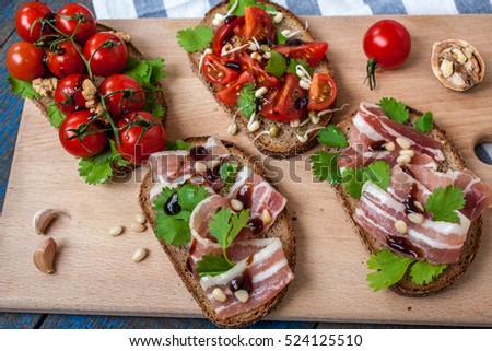 Top view of the open sandwiches with bacon and tomatoes. Good beer and wine. Love for a European healthy raw food concept.