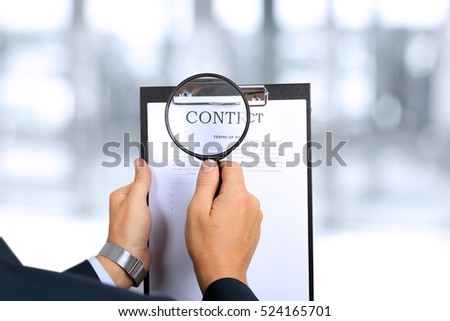 man looking through a  magnifying glass  to the Blank of contract 