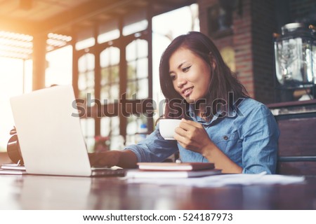 Beautiful hipster woman using laptop at cafe while drinking coffee, Relaxing holiday concept. Royalty-Free Stock Photo #524187973
