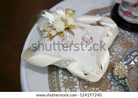 gold rings for wedding are on decorative pillow