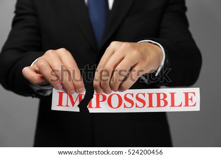 Businessman tearing paper with impossible word