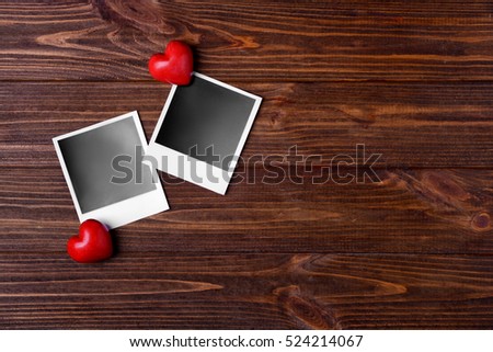 Photos and hearts on wooden background