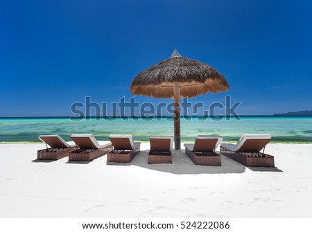 Sun umbrella and beach beds on tropical coastline
 Royalty-Free Stock Photo #524222086