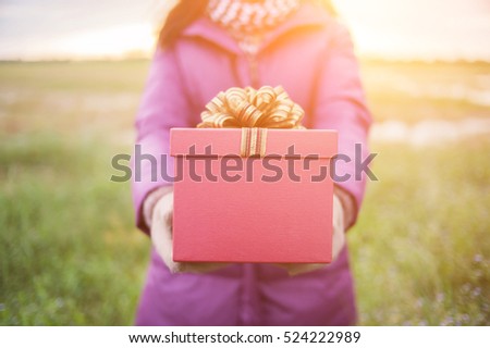 Gift is ready for you. Woman holding present.