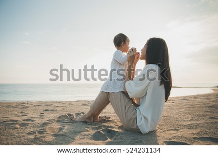 Beautiful Mother And Baby outdoors. Mum and her Child together enjoying sunset