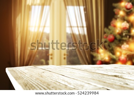 Wooden desk space and background of xmas tree and window of sun light 