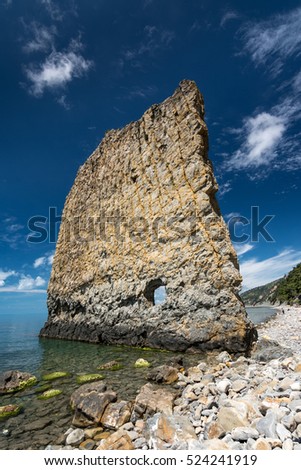 Vertical cliff with hole inside named Skala Parus on the coast of Black Sea. Gelendzhik district, Russia. Royalty-Free Stock Photo #524241919