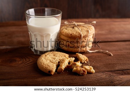 Cookies and milk. Chocolate chip cookies and a glass of milk. Vintage look. Tasty cookies and glass of milk on rustic wooden background. Food, junk-food, culinary, baking and eating concept