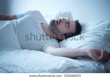 Man sleeping in his bed and snoring loudly Royalty-Free Stock Photo #524260453