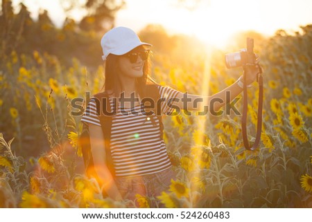 Portrait of a young attractive woman making selfie photo of Sunflower.Fair Lens Sun
