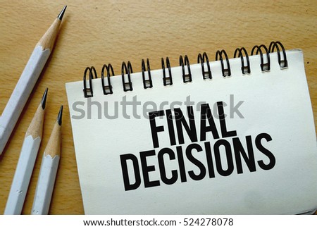 Final Decisions text written on a notebook with pencils