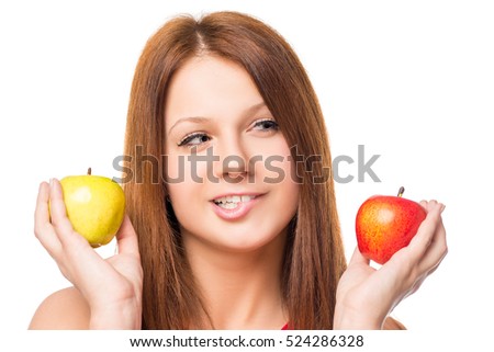 thoughtful girl makes a choice between apples on a white background isolated 