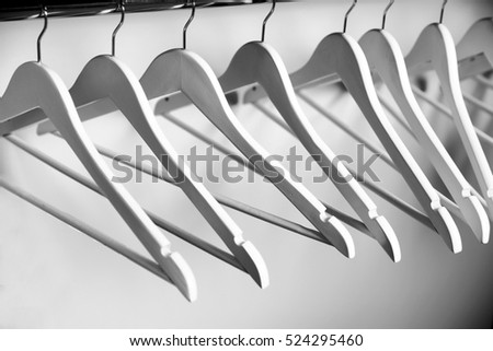 Clothes hangers in empty wardrobe, closeup